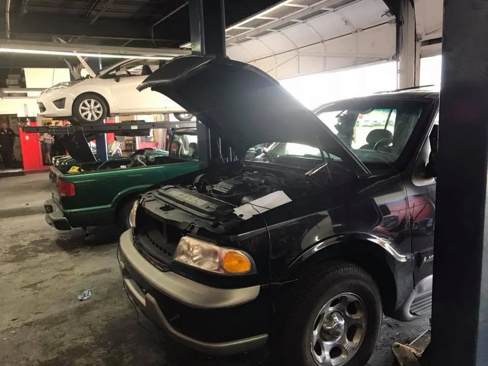 A customer vehicle with its hood open inside Lakeland Auto Service