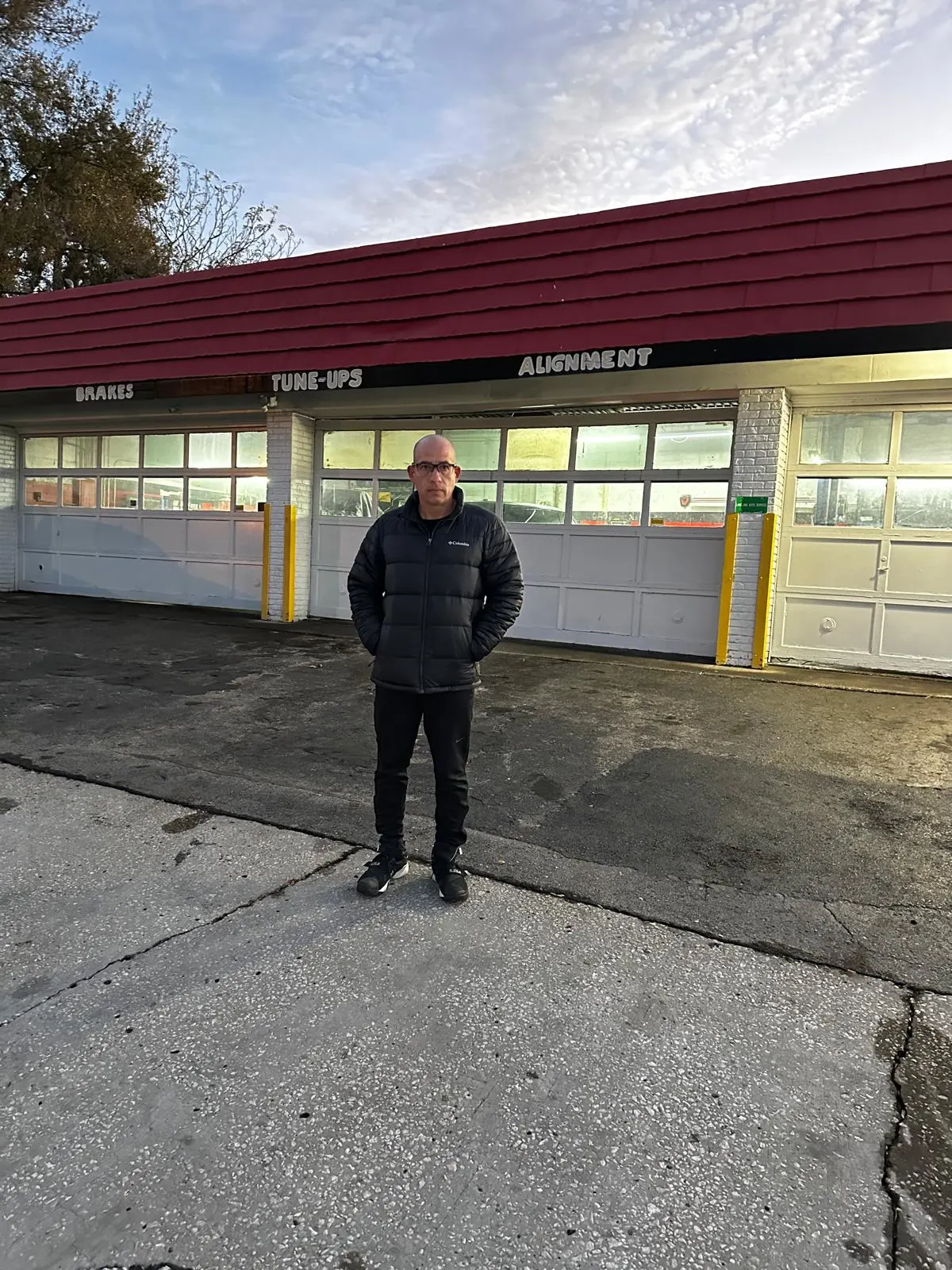 Arturo Morales, owner of Lakeland Auto Service, standing in front of the service bays